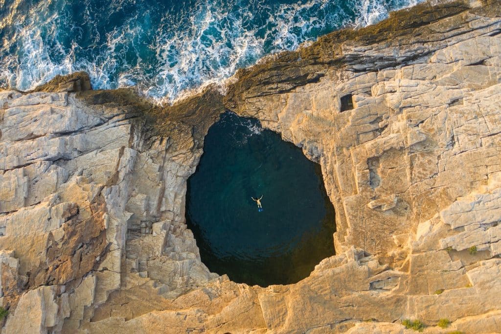 Aerial drone view of a girl swimming Giola lagoon